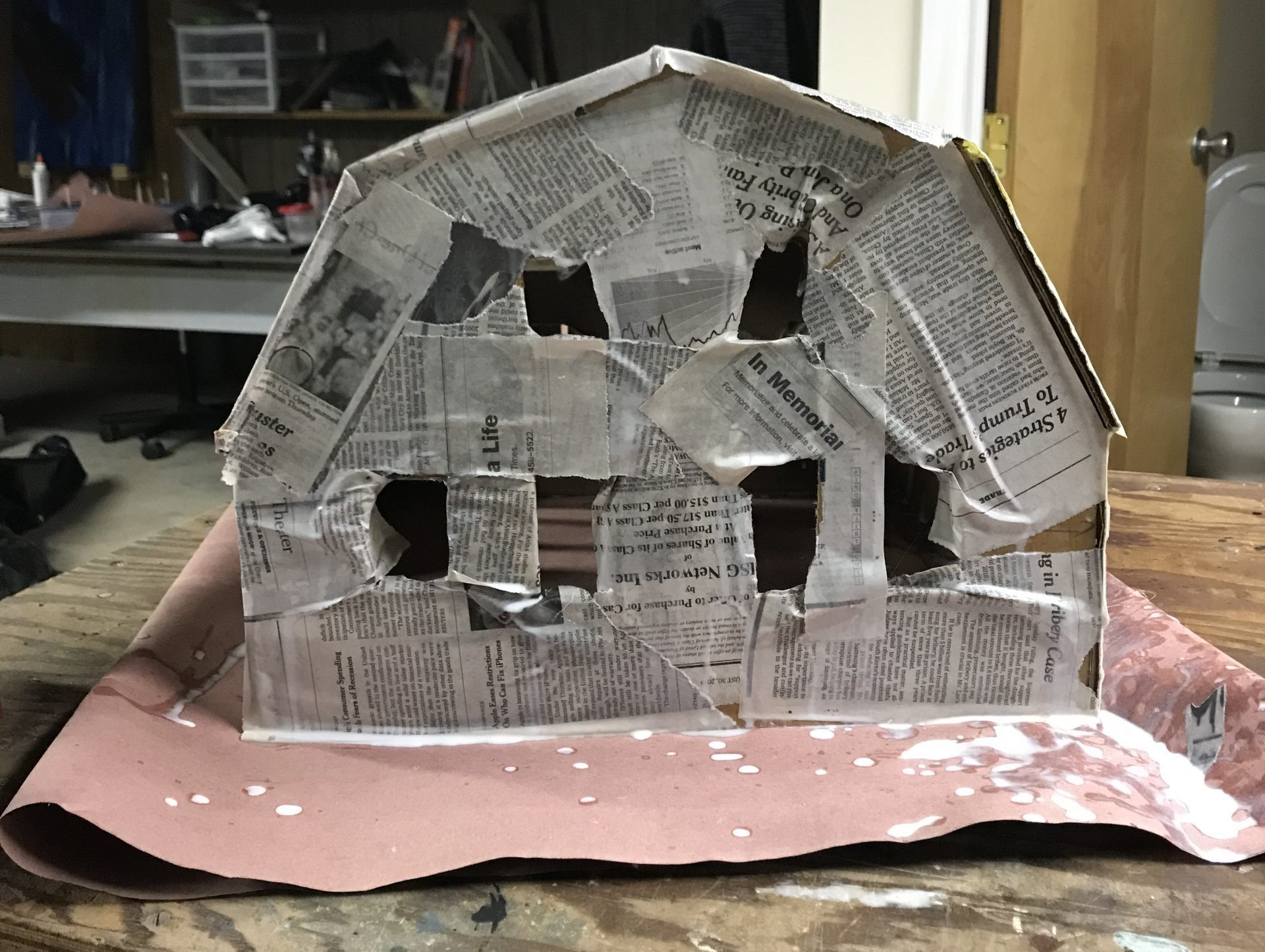 Applying paper mache newspaper strips to the cardboard Elm Street house frame