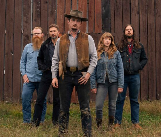 Lost Dog Street Band promo image for their album 'Survived', featuring Benjamin Tod and Ashley Mae.