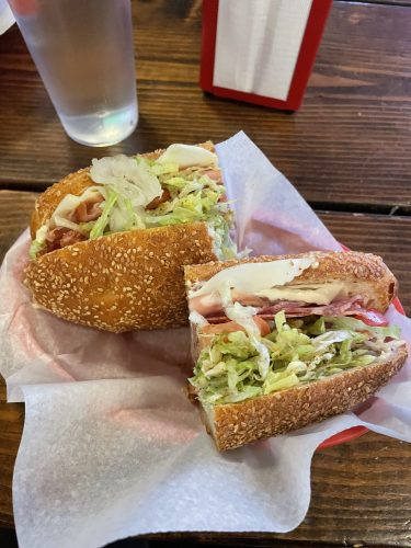 Italian Combo sandwich shown in a plastic tray at a table in Mario