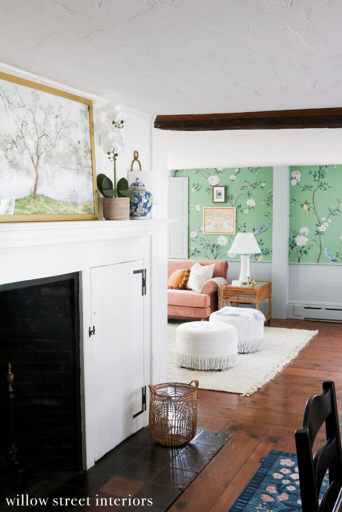 A vibrant living room designed by Willow Street Interiors, showcasing a bold patterned sofa, colorful artwork, and layered textiles that create a grand millennial inspired space with eclectic flair.