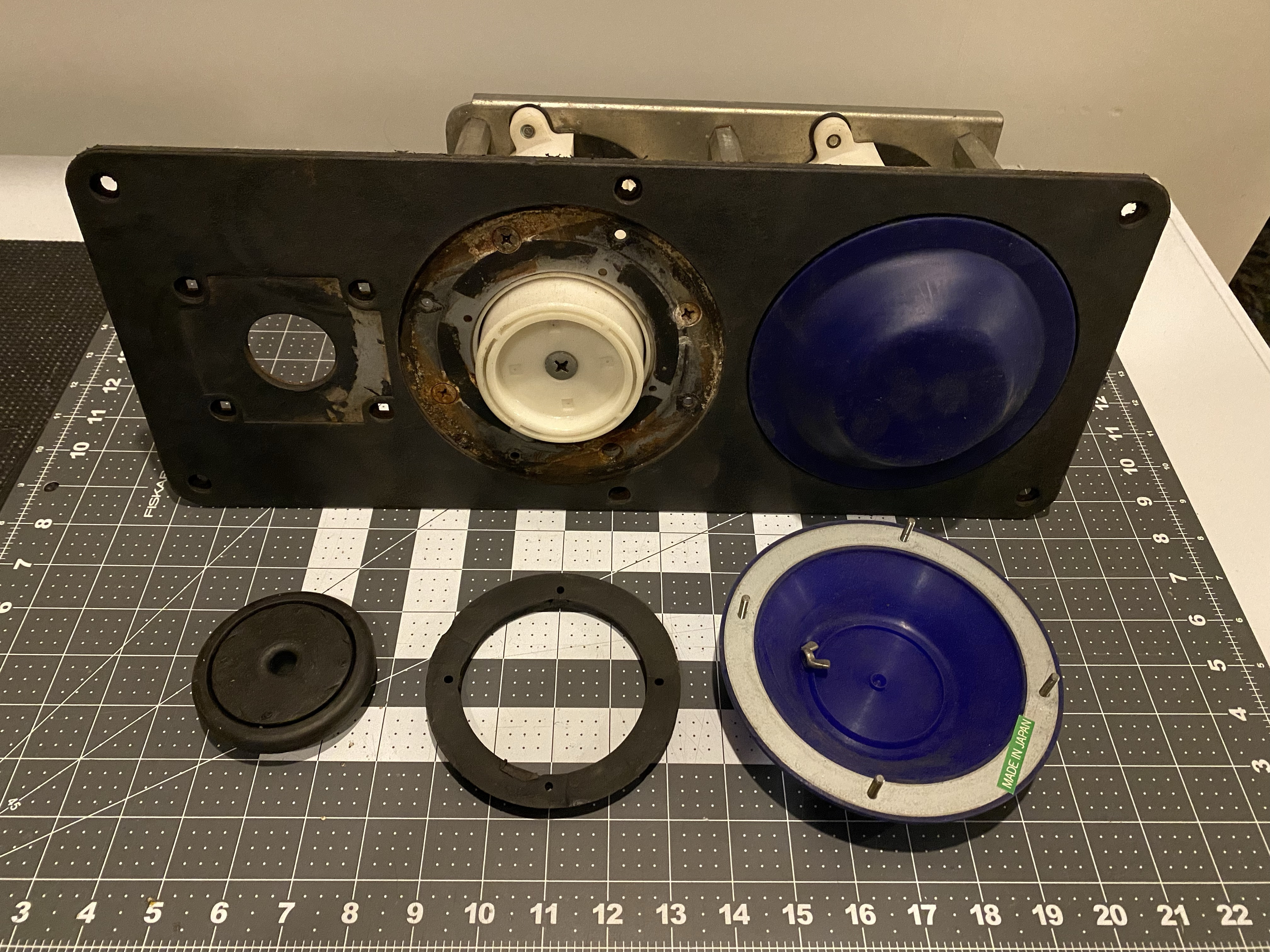 A pneumatic control panel with a bash pad removed, revealing the white pneumatic cylinder.