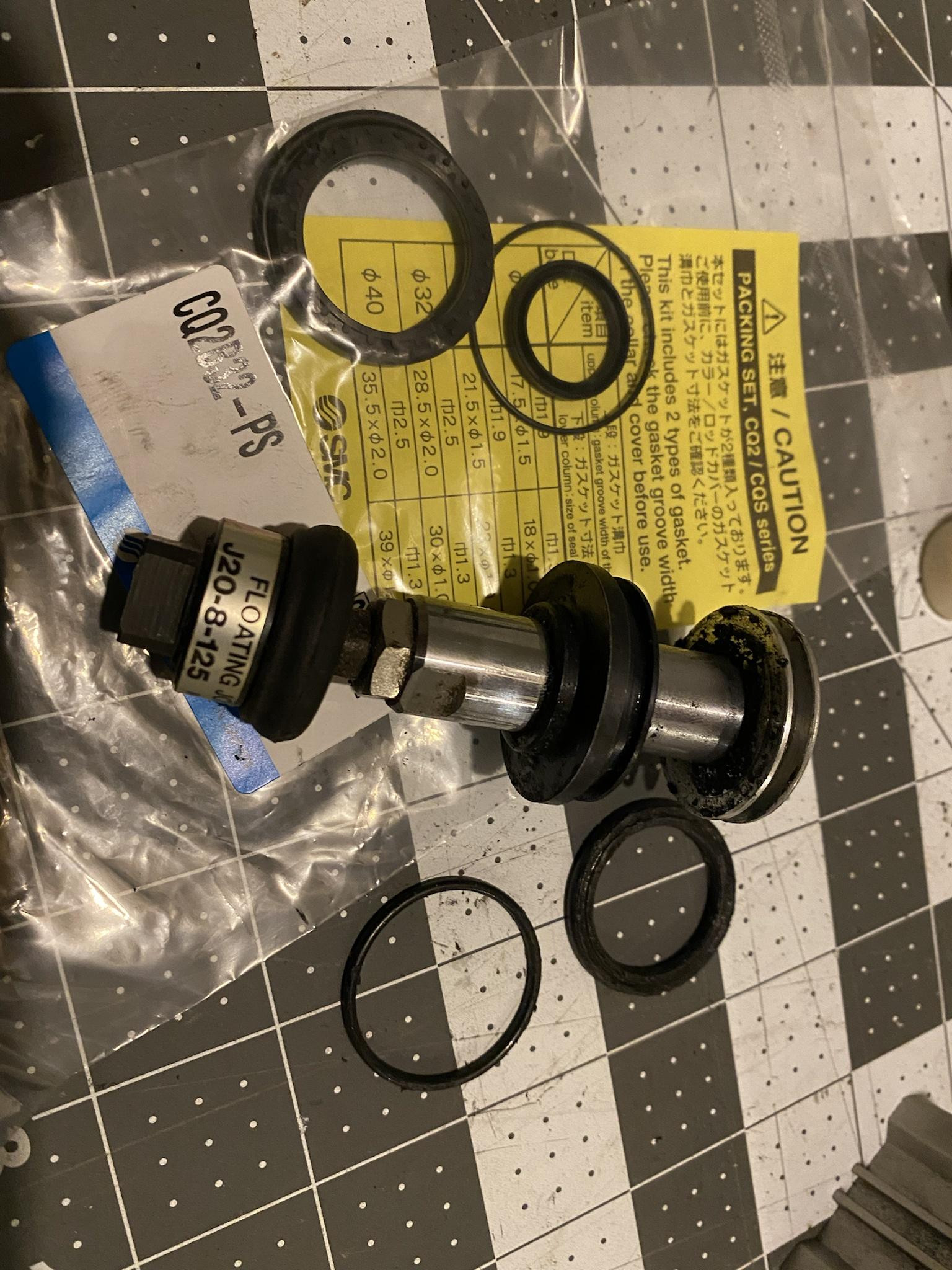 The pneumatic piston and O-rings in need of refurbishment, demonstrating potential wear points.