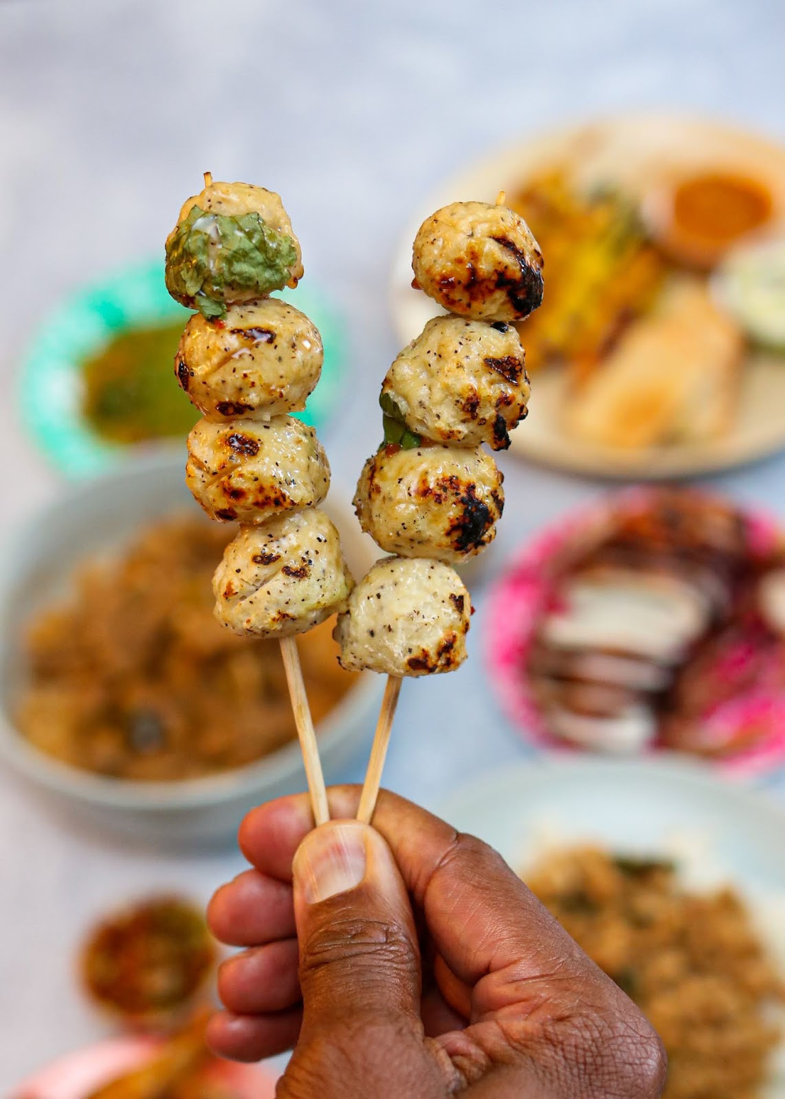 Delicious skewers of Look Shin Gai Ping, Thai grilled chicken meatballs, served with a side of sweet tamarind dipping sauce at JJ Thai Street Food.