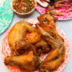 A vibrant and flavorful plate of Peek Gai Tod, crispy Thai chicken wings, served at JJ Thai Street Food in Chicago.