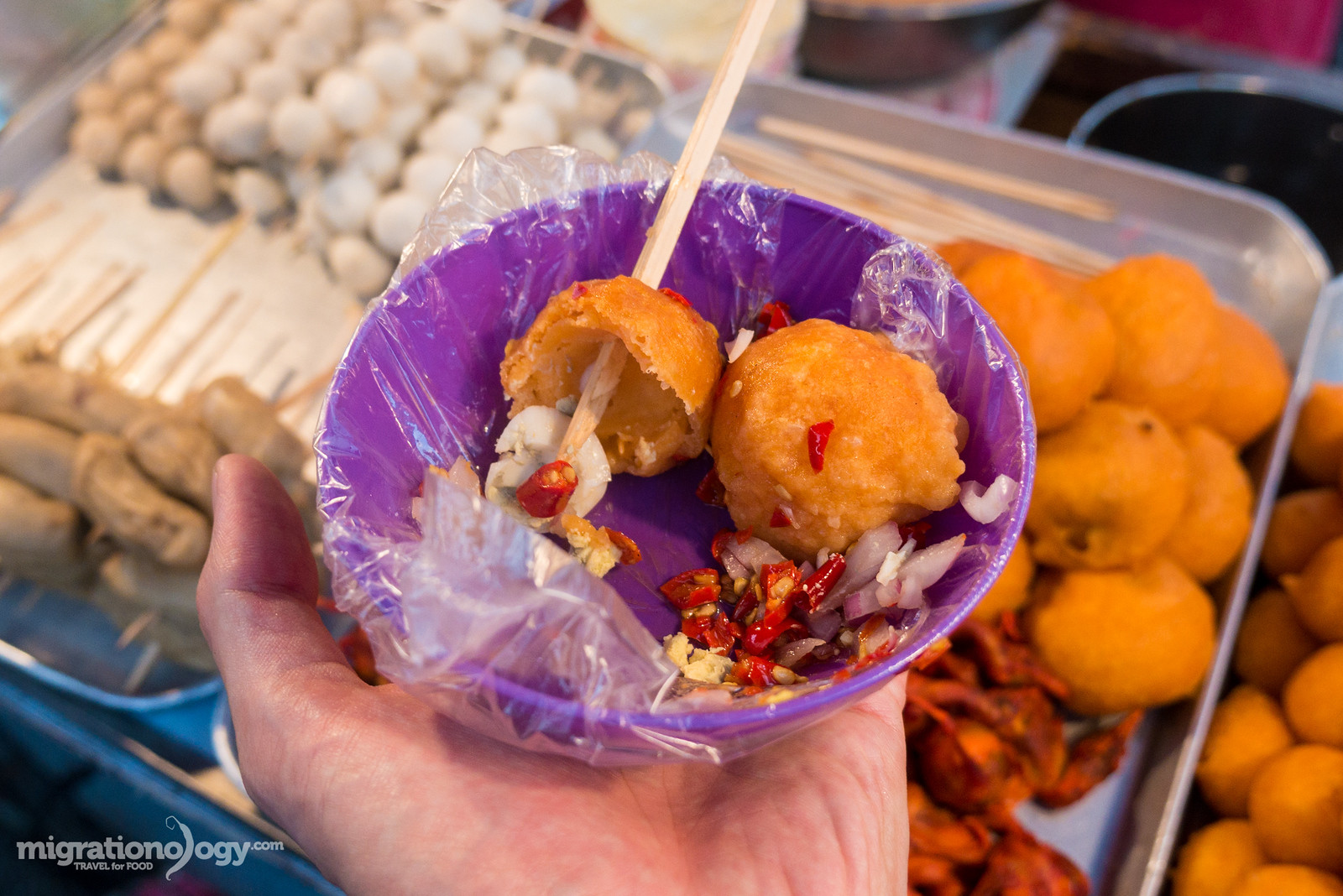 Deep-fried quail eggs in orange batter known as Kwek Kwek, a popular Filipino street food.