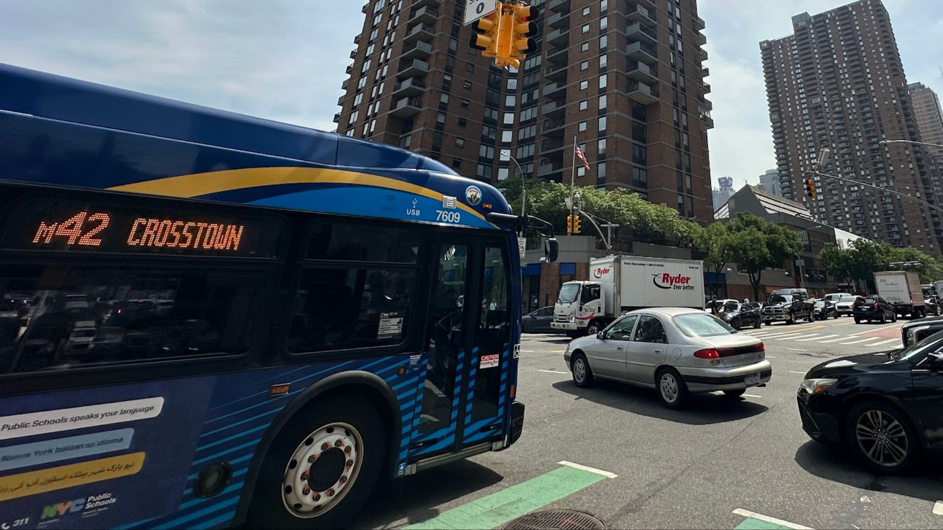 M42 crosstown bus traveling on W 42nd Street in New York City, illustrating improved bus speeds due to congestion charge implementation.