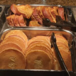 Assortment of breakfast foods including eggs, bacon, and pastries at Main Street Station Buffet
