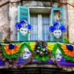 A vibrant street scene in New Orleans' French Quarter during Mardi Gras, showcasing colorful buildings and lively crowds.