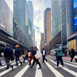 Pedestrians Cross W42nd Street in Midtown Manhattan, New York City, showcasing increased foot traffic due to congestion pricing.