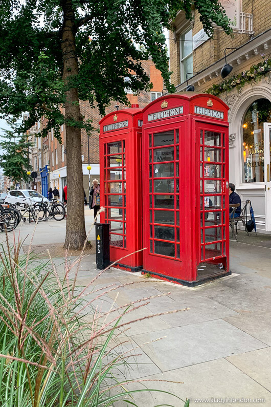 Iconic red telephone boxes on Marylebone High Street, London, adding a touch of British charm to the street scene.