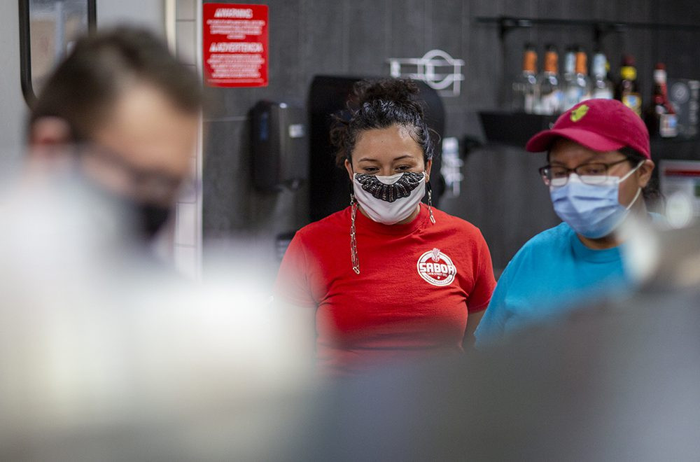 Miriam Espaillat, co-founder of Sabor Latin Street Grill, stands proudly in her restaurant, showcasing her commitment to community and authentic Latin cuisine.