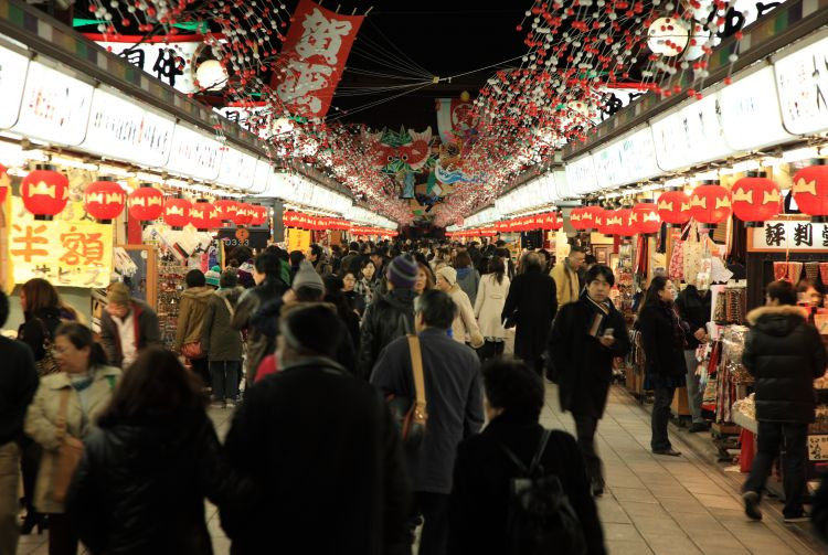 A bustling scene along Nakamise-dori street, lined with traditional shops and vibrant with visitors in Asakusa, Tokyo.