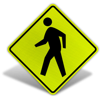 Yellow pentagon street sign with pedestrian symbol, indicating a pedestrian crossing area.