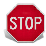 Red stop sign, a regulatory street sign indicating drivers must come to a complete stop.