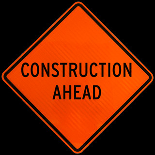 Orange roll up street sign with black text indicating 'Construction Ahead'.