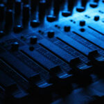 A musician mixes audio tracks on a soundboard for adding youtube sound to tiktok.