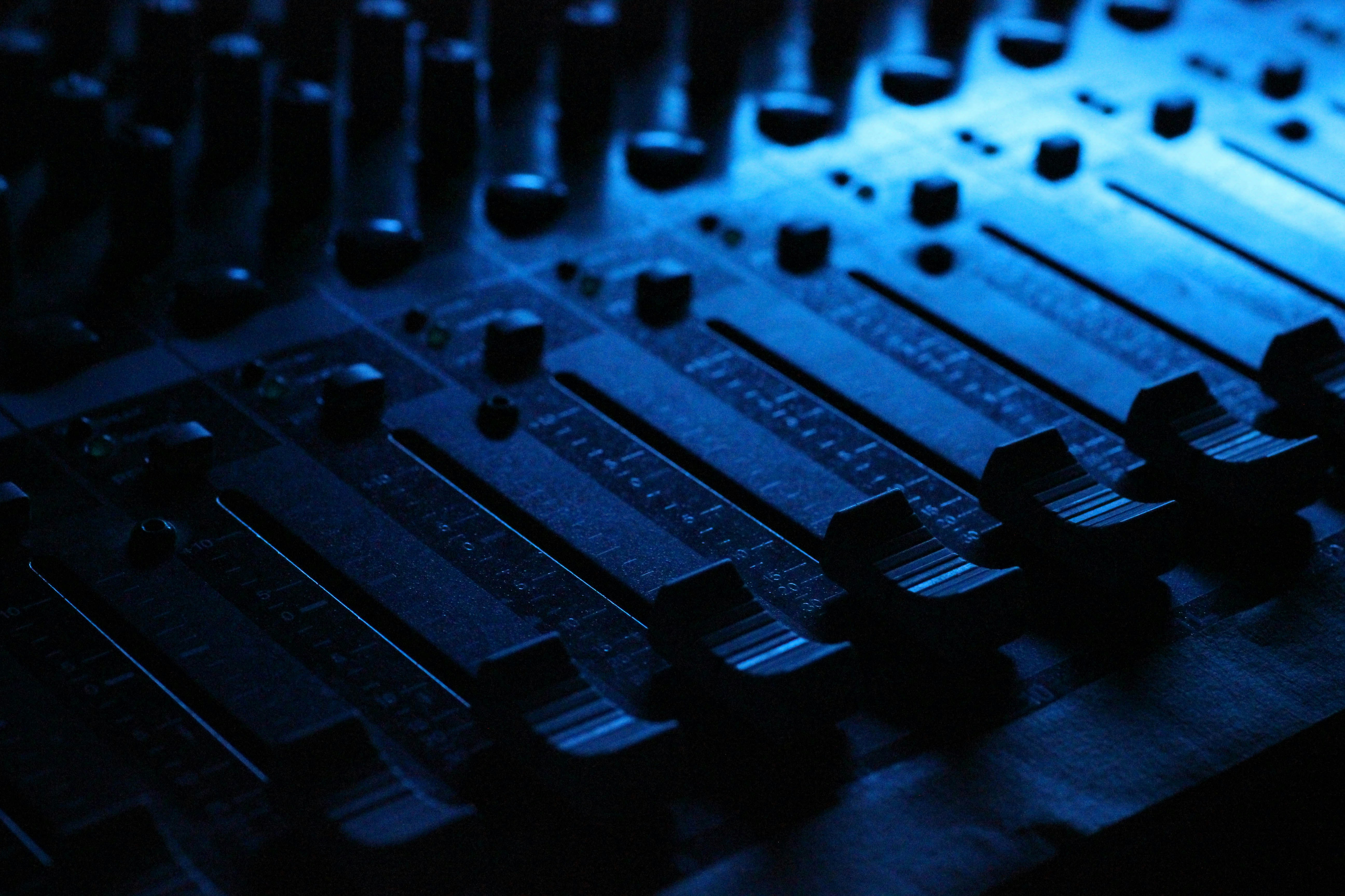 A musician mixes audio tracks on a soundboard for adding youtube sound to tiktok.